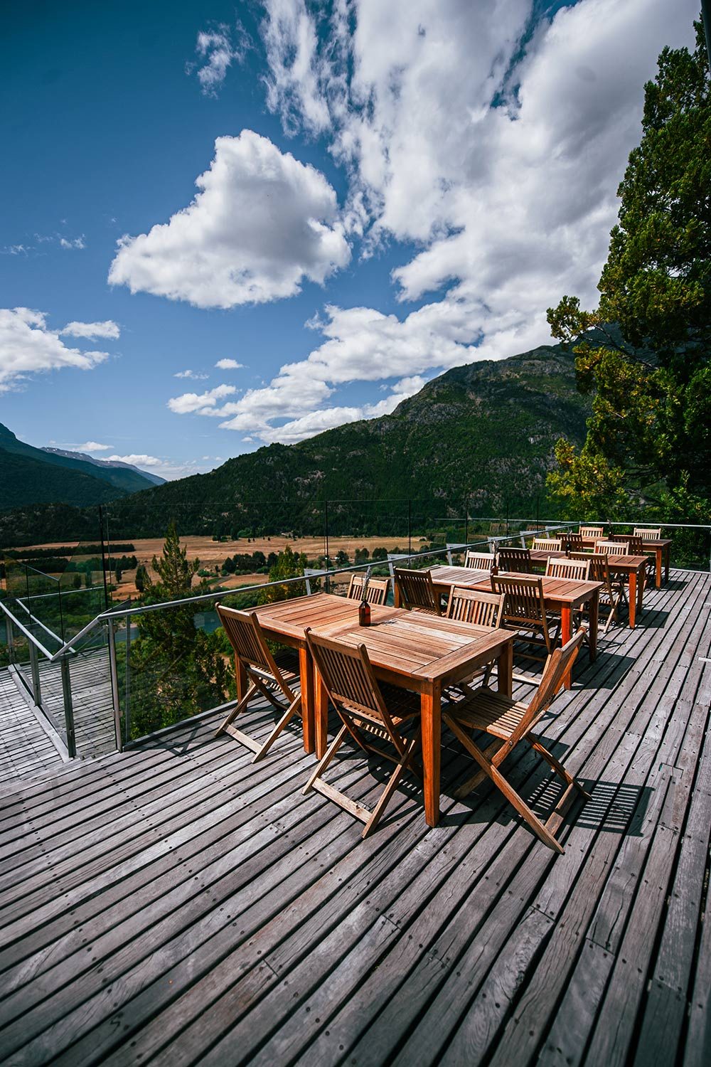 Wooden tables on the terrace above the valley and river