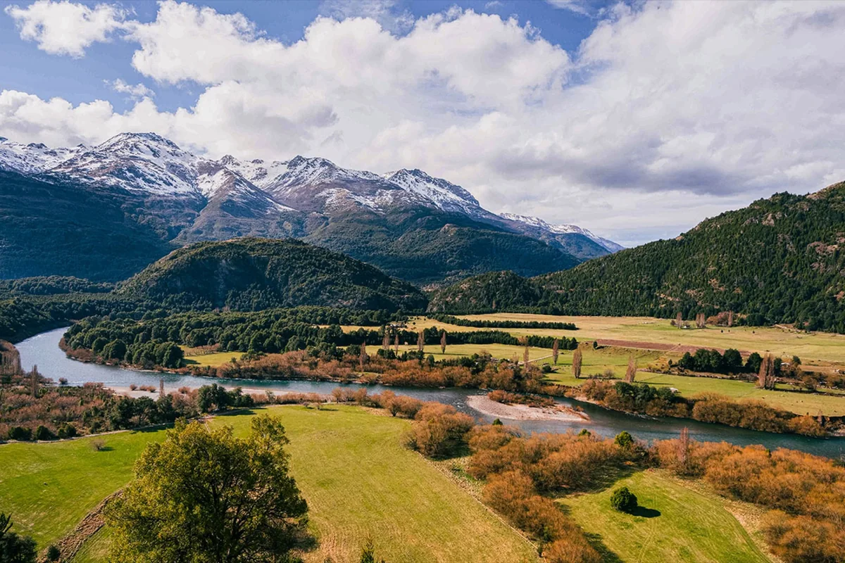 El valle del río Futaleufú con la cordillera nevada al fondo y praderas en primer plano