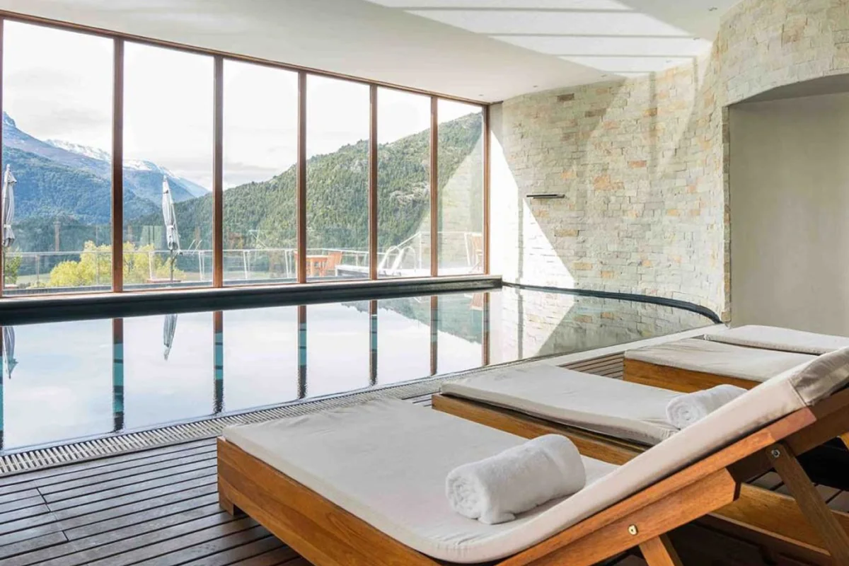 Piscina interior temperada del spa de Uman Lodge, con ventanales hacia el bosque y la cordillera
