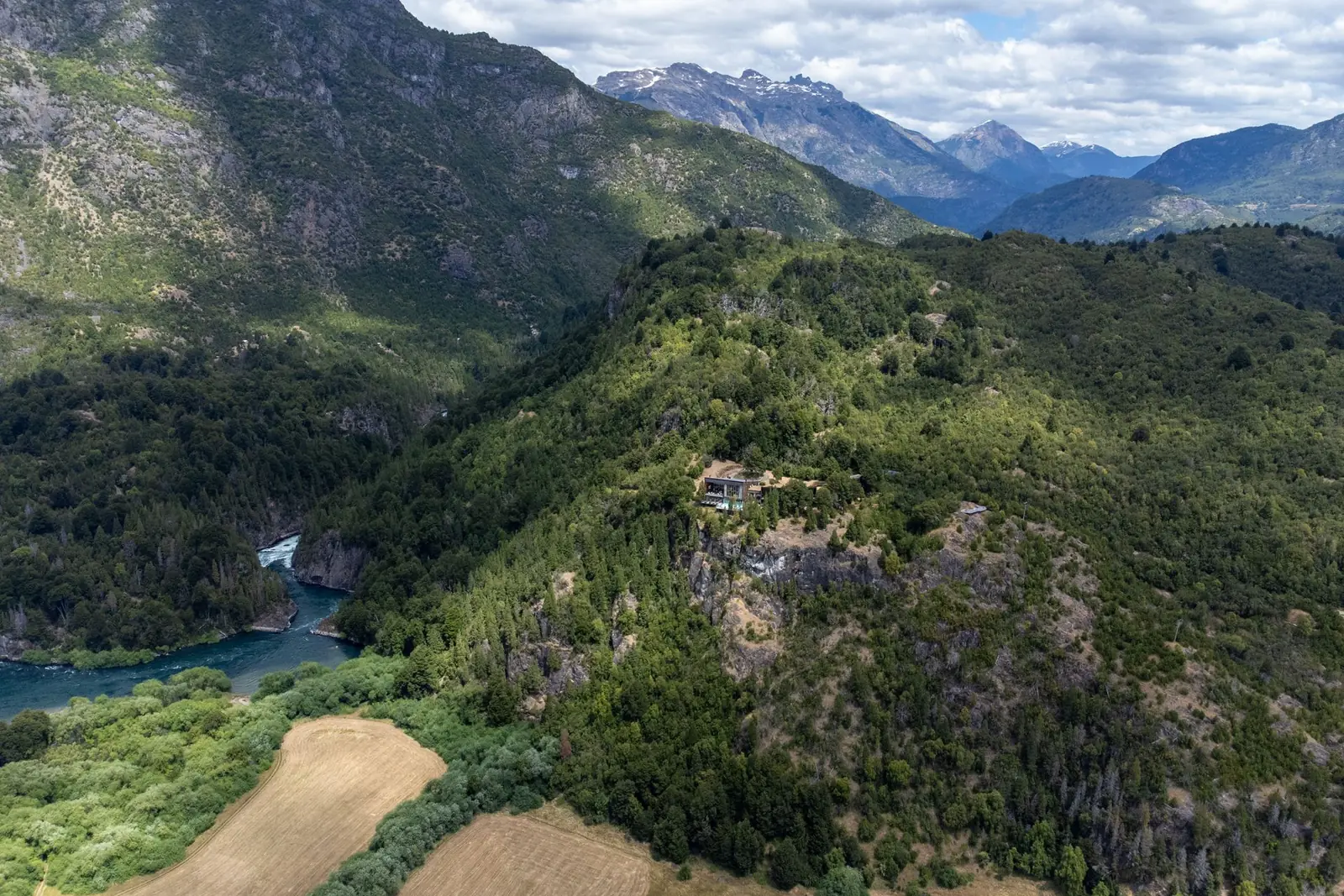 Vista aérea del valle del río Futaleufú, con Uman Lodge entre el bosque y la cordillera al fondo