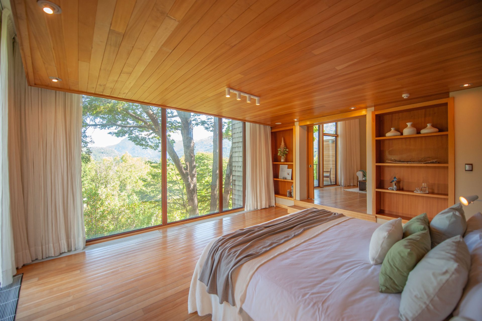 Suite principal con cama king y ventanal al bosque
