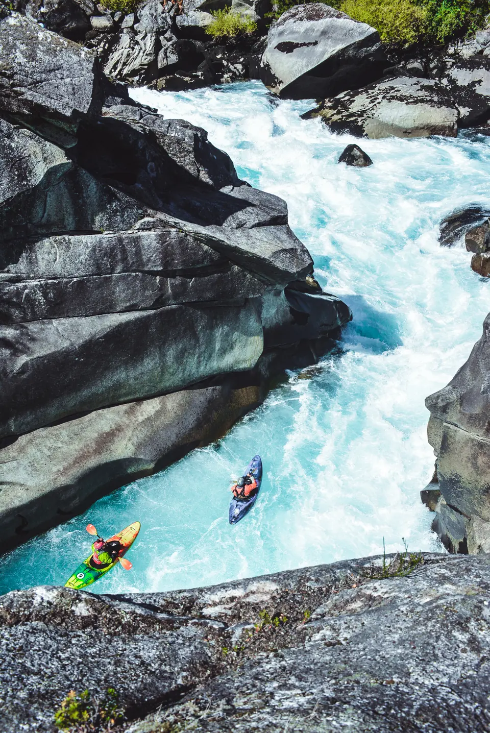 Two kayakers in a granite canyon of the Futaleufú, white and turquoise water between the rocks