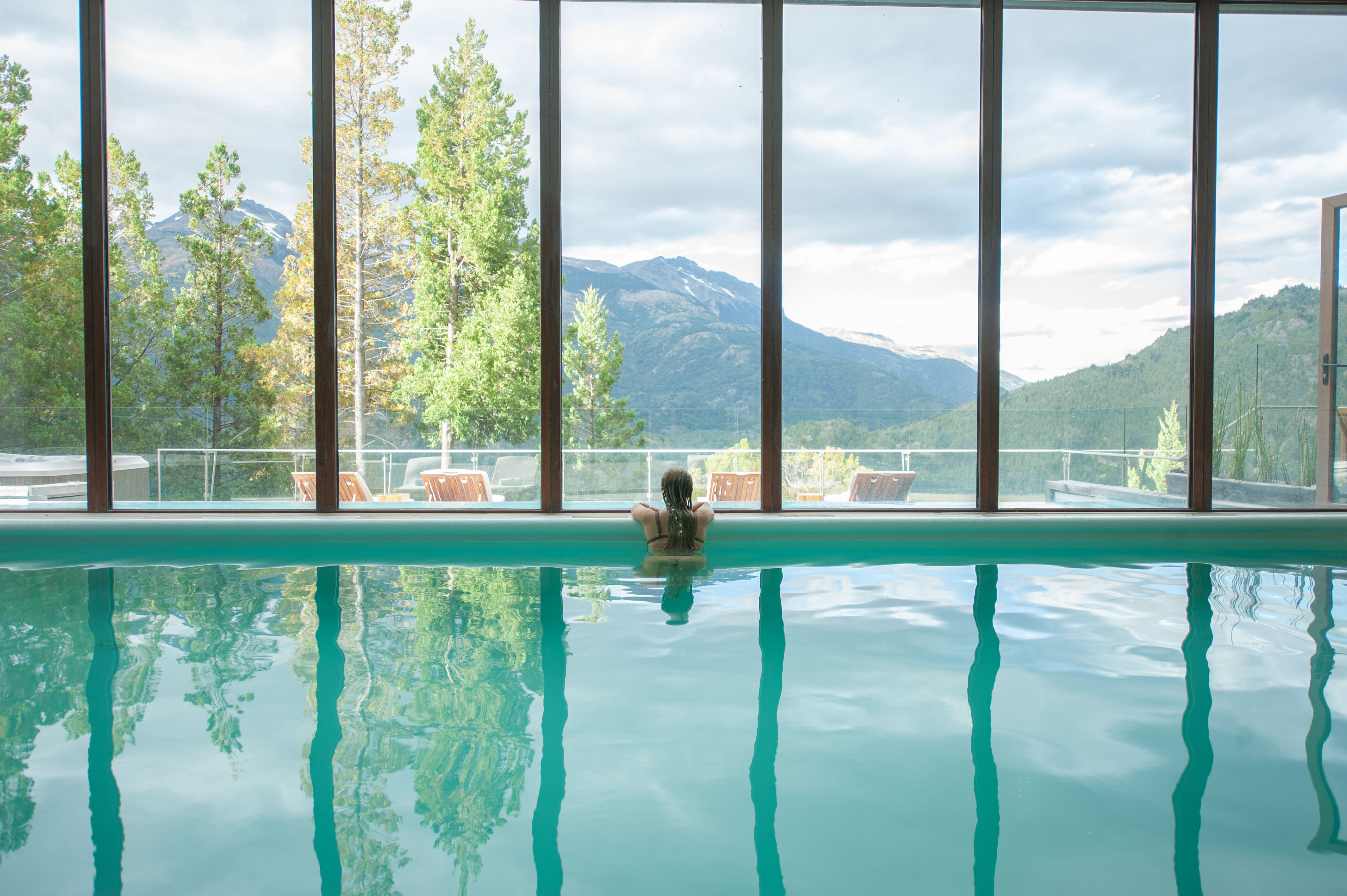 Piscina climatizada interior con grandes ventanales al valle